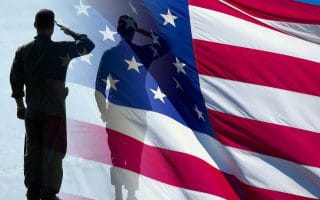 United States Marines wearing Dress Blues at the Mauthausen complex in Austria standing with the American flag and United States Marine Corps flag