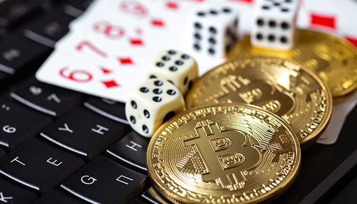 Bitcoin Coins with Casino Dice and Cards on a Laptop Keyboard